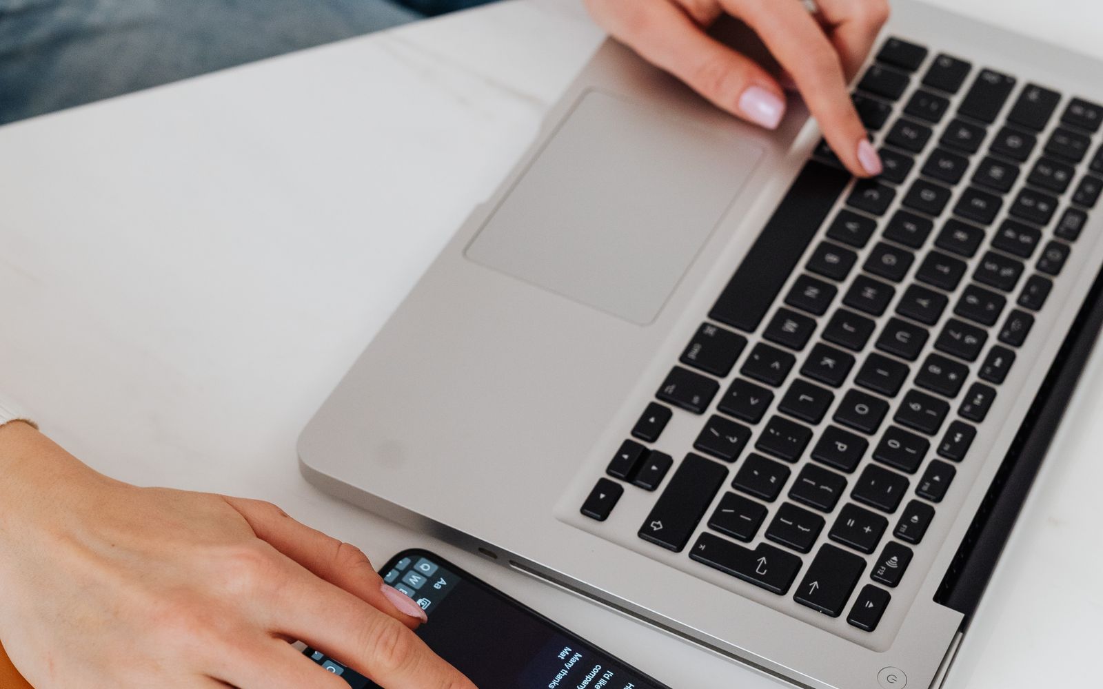 Laptop i smartfon używane razem na stanowisku pracy