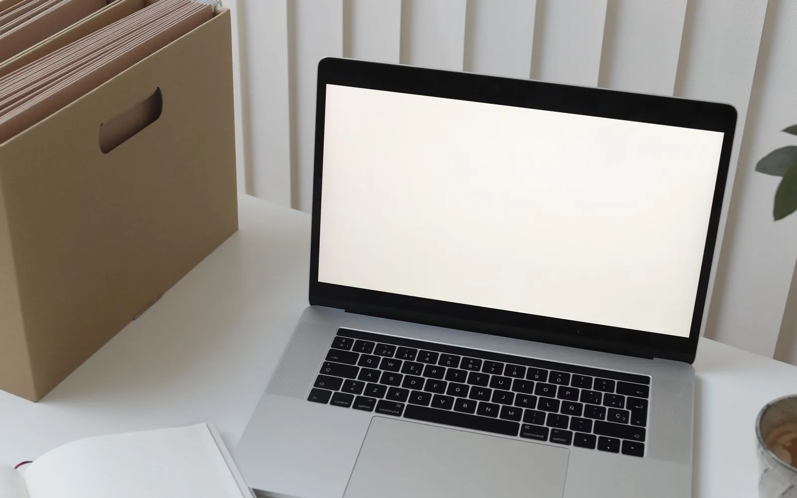 Laptop na jasnym biurku z notatnikiem i wyposażeniem biurowym podczas porządkowania środowiska Microsoft 365